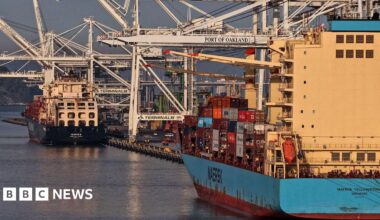 Container ships are seen docked at a port.