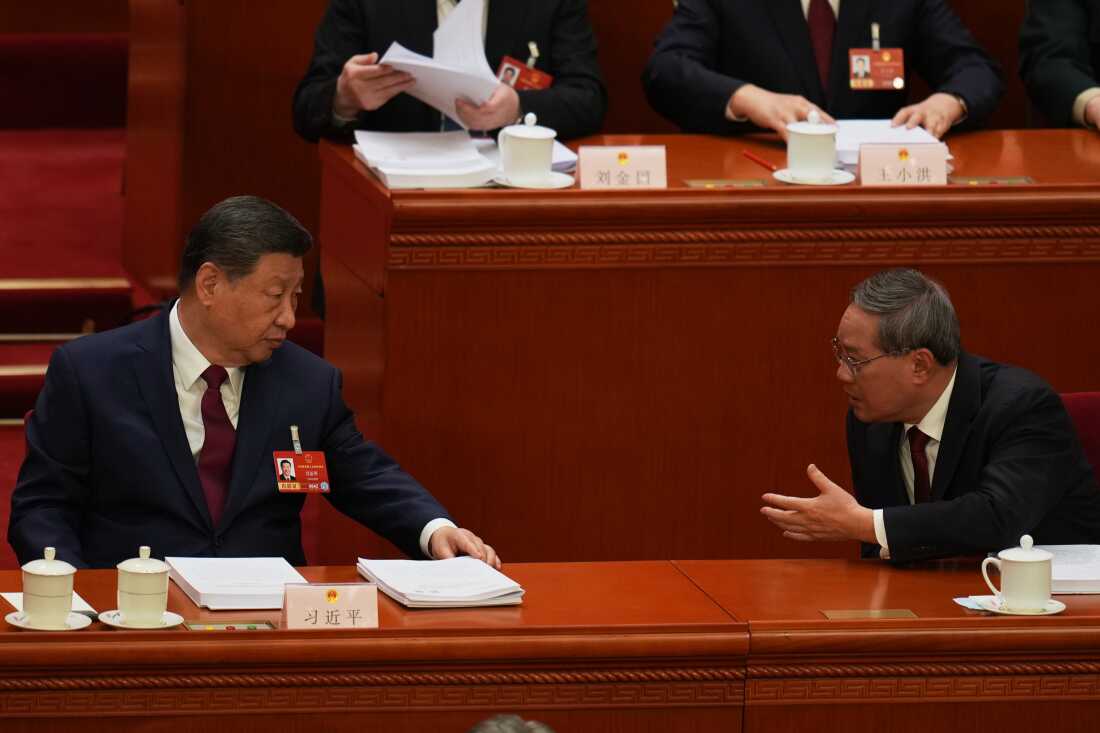 Chinese President Xi Jinping, left and Chinese Premier Li Qiang chat during the opening session of the National People's Congress (NPC) in Beijing, Thursday, March 5, 2026.