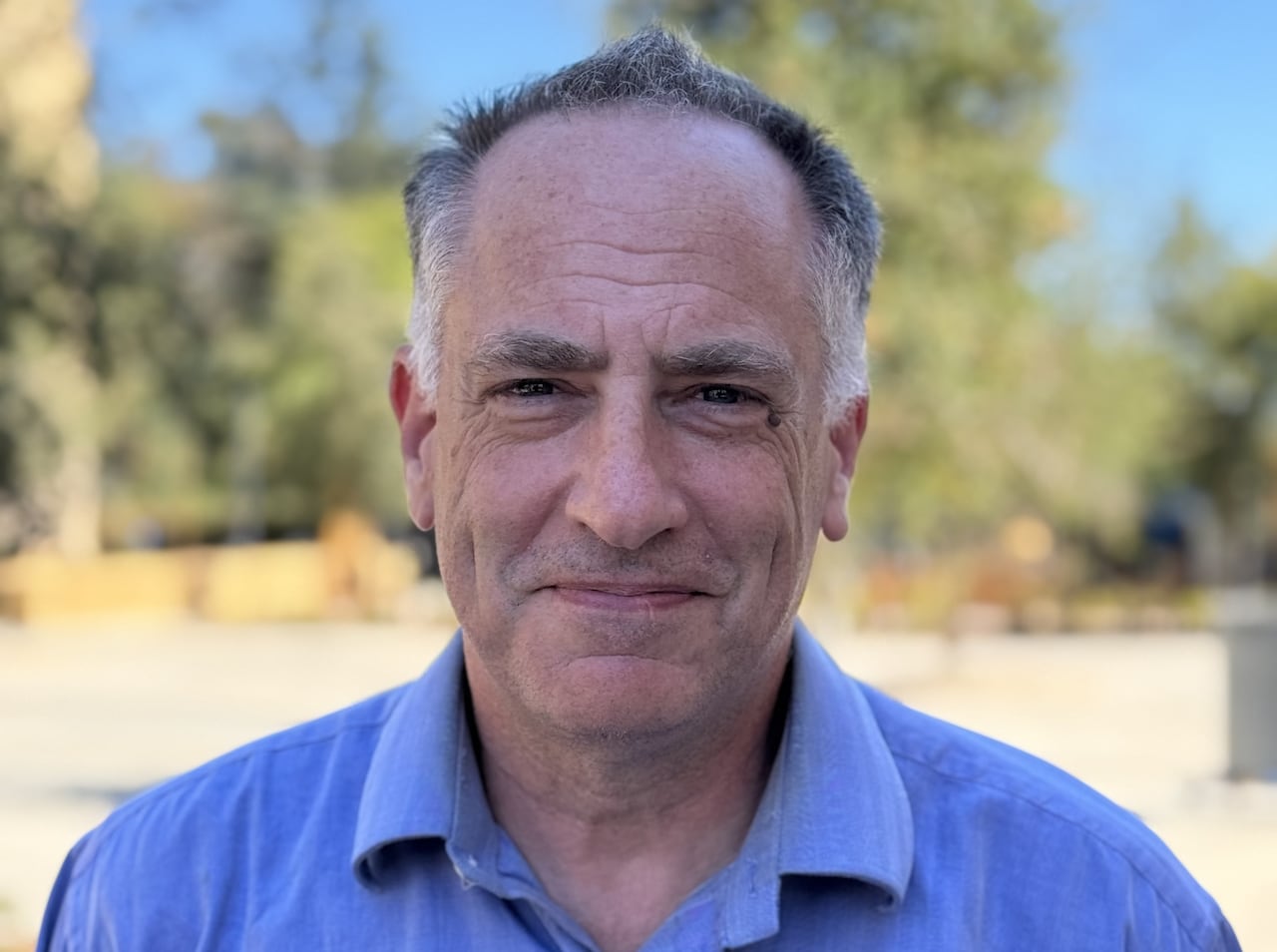 Portrait of a man in a blue shirt.