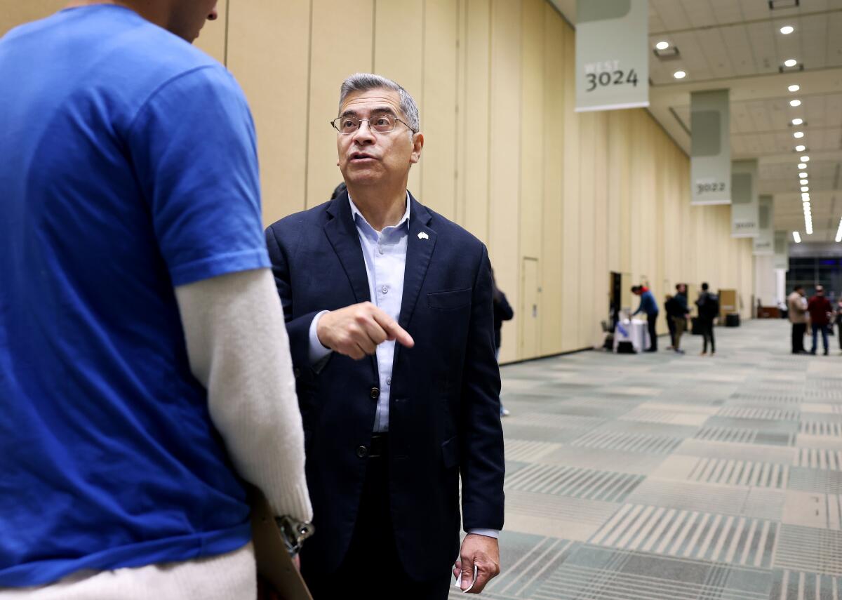 Xavier Becerra talks with a person