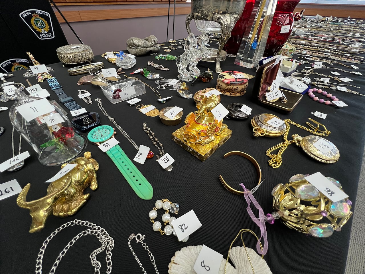 A photo of hundreds of stolen items on display including watches, jewelry and trinkets.