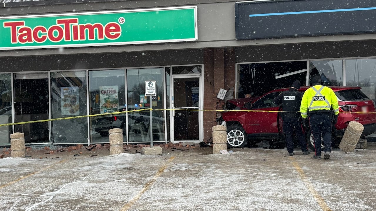 A red SUV is crashed into the front of a store