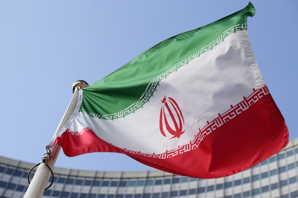 The Iranian national flag flies during a special session of an IAEA Board of Governors meeting in Vienna, Austria, March 2, 2026. (AP Photo/Heinz-Peter Bader, file)