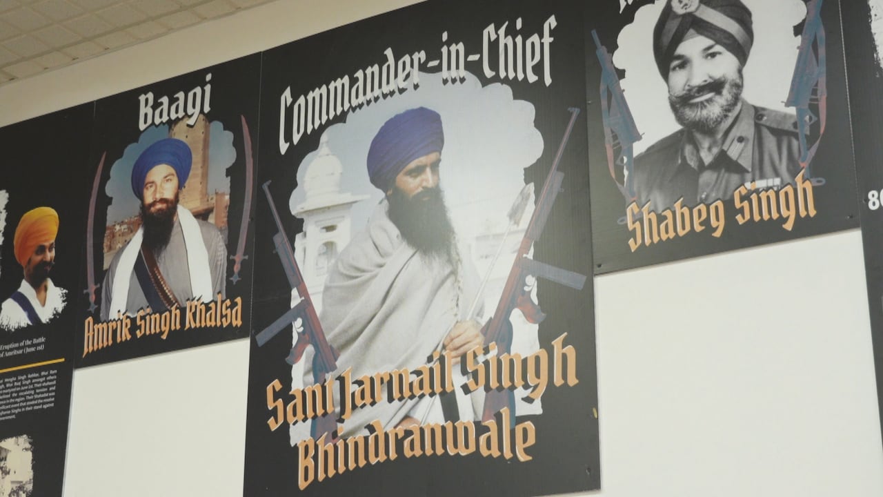 A photo of a man flanked by two guns