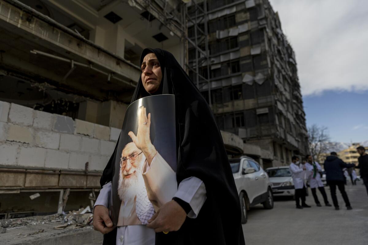 A women holds a portrait of the late Ayatollah Ali Khamenei at a protest