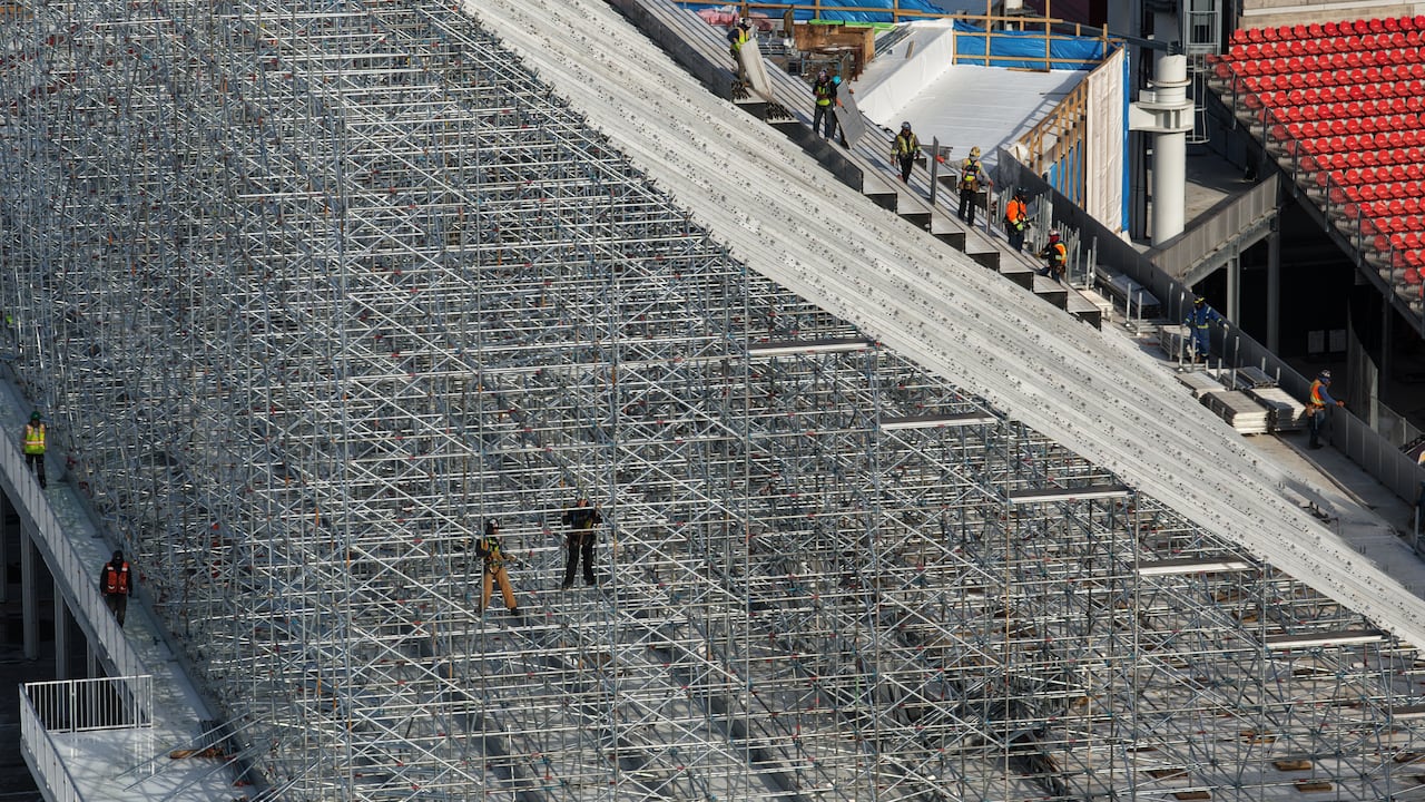 People working on scaffolding for temporary seats at soccer field