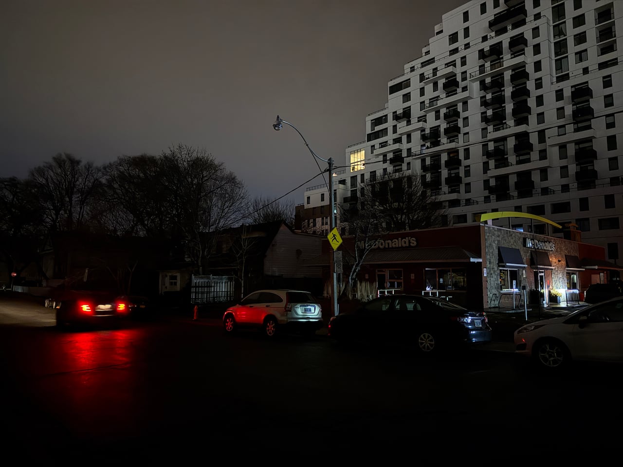 Cars by a dark road.