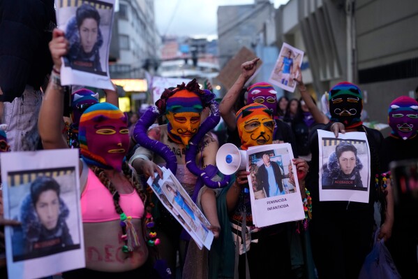 Women hold photos of people who they accuse of being victimizers of women during a march marking the upcoming International Women's Day, in La Paz, Bolivia, Friday, March 6, 2026. (AP Photo/Juan Karita)