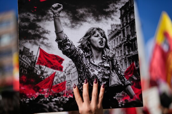 A woman holds up a placard during a protest marking the International Women's Day, in Istanbul, Turkey, Sunday, March 8, 2026. (AP Photo/Khalil Hamra)