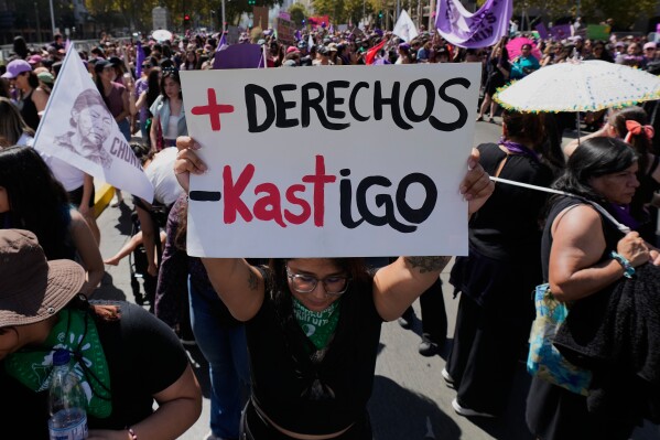 A woman holds a banner reading in Spanish "More rights, less punishment" making a wordplay reference to Chilean President-elect Jose Antonio Kast during an International Women's Day protest in Santiago, Chile, Sunday, March 8, 2026. (AP Photo/Esteban Felix)