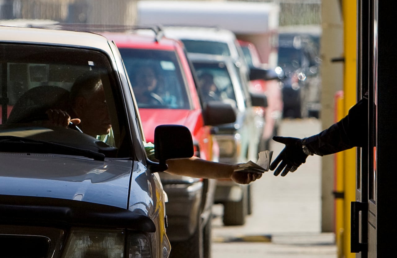 A person hands a document over at a border crossing.
