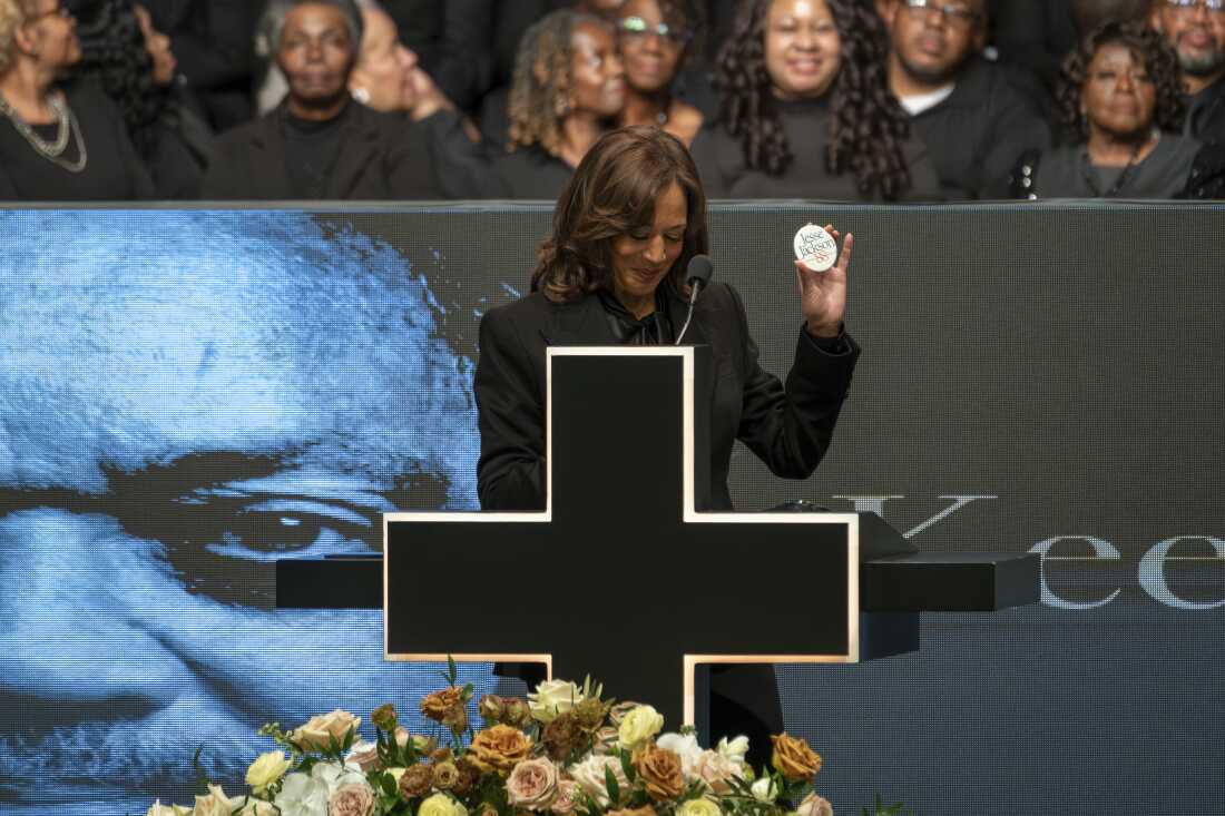 Former Vice President Kamala Harris holds a campaign button from the Rev. Jesse Jackson’s 1988 presidential run while speaking during Jackson's public homegoing service at the House of Hope in Chicago on Friday.