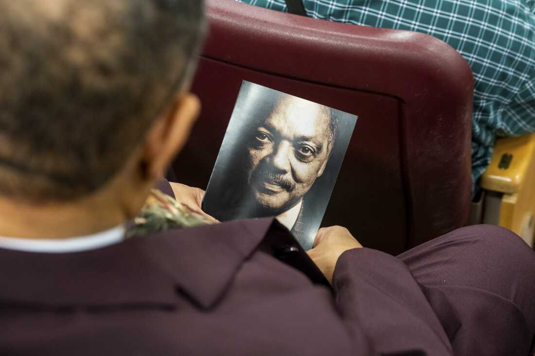 An attendee holds a memorial program featuring the Rev. Jesse Jackson at the House of Hope on Friday.
