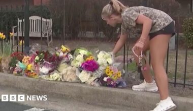 A person places flowers at a memorial
