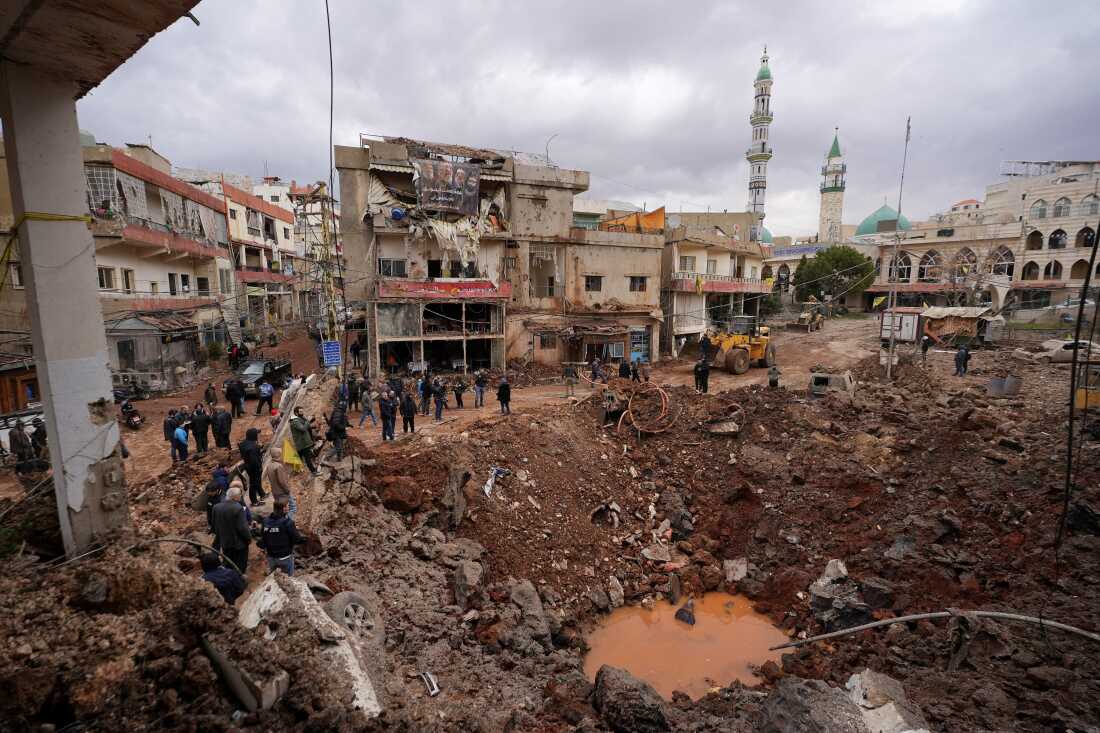 People inspect the damage where Israel's military carried out an airborne operation that dropped troops overnight, in the town of Nabi Chit, Lebanon.