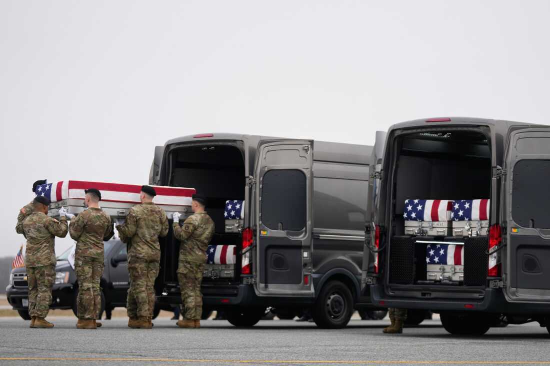 An Army carry team moves a flag-draped transfer case with the remains of Sgt. Declan Coady, 20, of West Des Moines, Iowa, who was killed in a drone strike at a command center in Kuwait after the U.S. and Israel launched its military campaign against Iran, past President Donald Trump and first lady Melania Trump during a casualty return at Dover Air Force Base, Del.