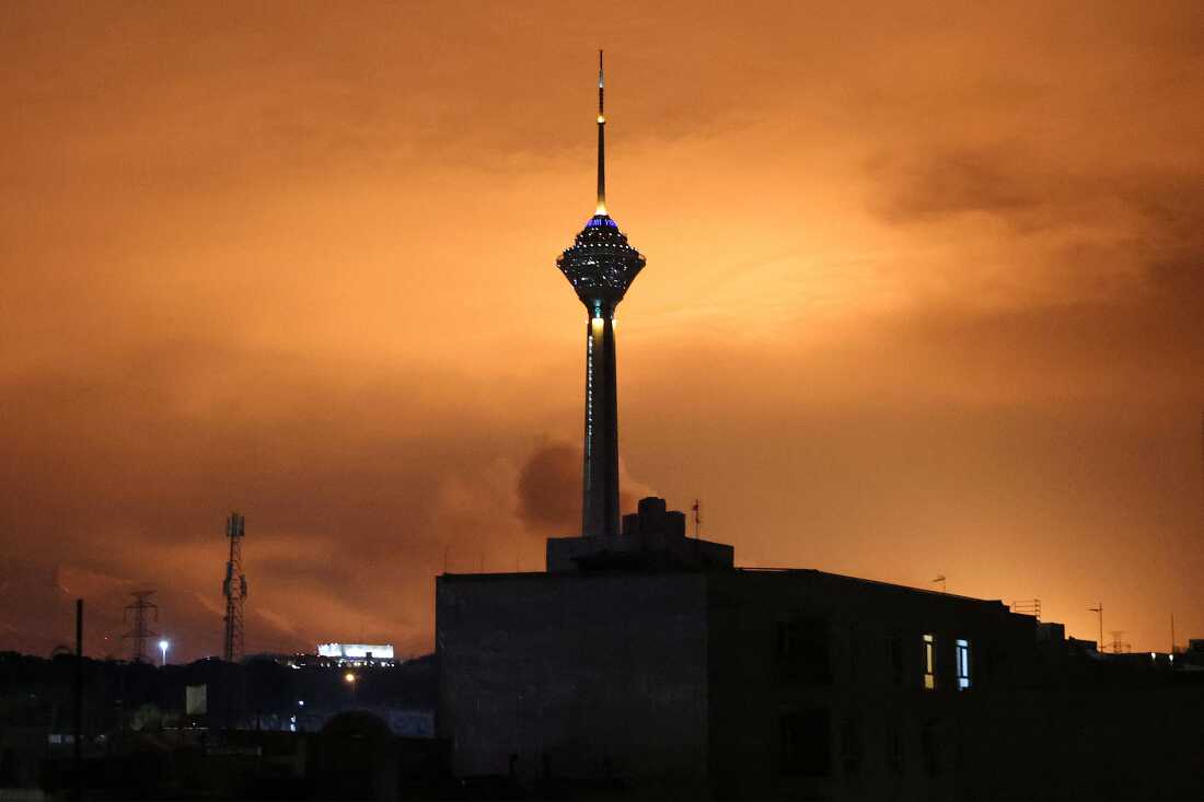 Milad (Birth) Tower, the tallest tower in Iran at 435 metres, is pictured before a lit up sky following airstrikes in Tehran on March 7, 2026.