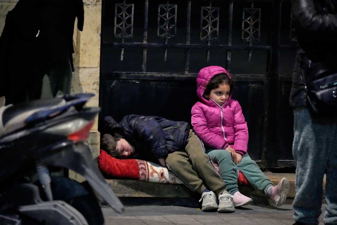 March 2: Children sit on a sidewalk as displaced families fleeing Israeli strikes in southern Lebanon arrive in the southern port city of Sidon.