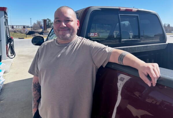 Francisco Castillo stands next to his son's Ford F-150 after filling up, Monday, March 9, 2026, at a gas station in De Soto, Iowa. (AP Photo/Hannah Fingerhut)