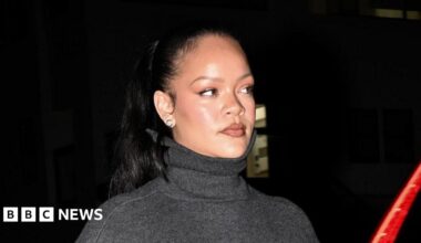 Rihanna wears a grey polo neck in a close-up.
