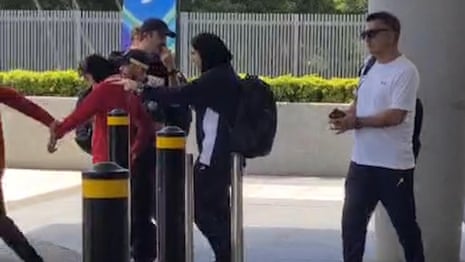 Iranian women’s football player led by wrist on to bus outside Gold Coast hotel – video