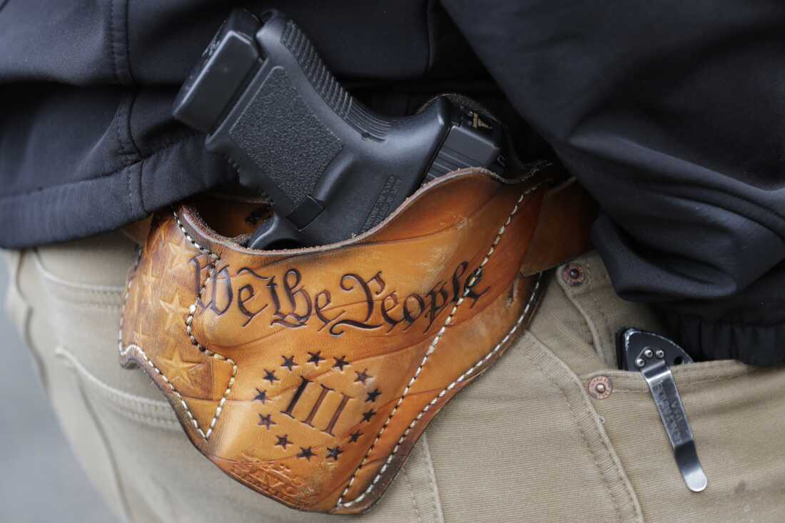 An attendee at a gun rights rally open-carries his gun in a holster that reads "We the People," from the Preamble to the U.S. Constitution, in this 2019 photo at the Capitol in Olympia, Wash.