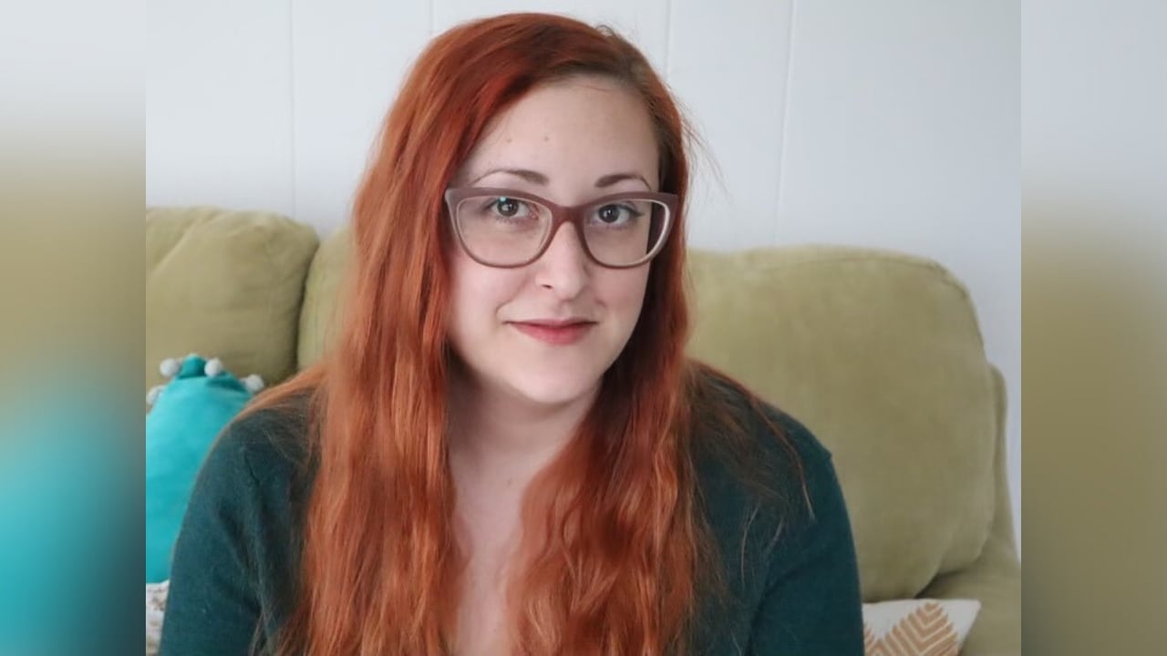 A woman with red ahir and glasses.