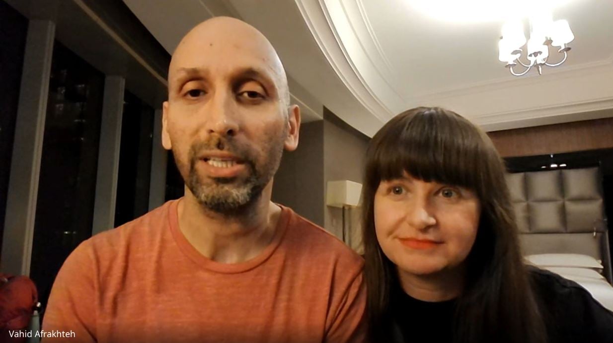 A man and woman in a hotel room at night.