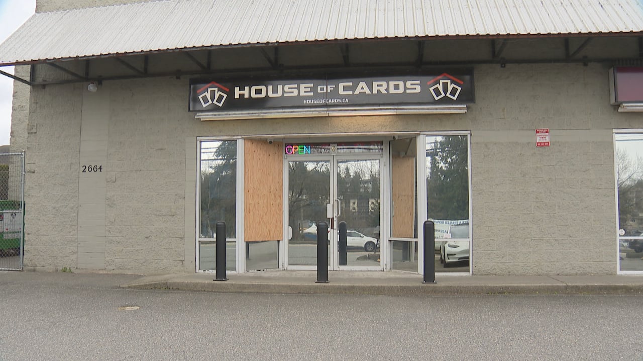 A store marked 'House of Cards' with boarded-up windows.