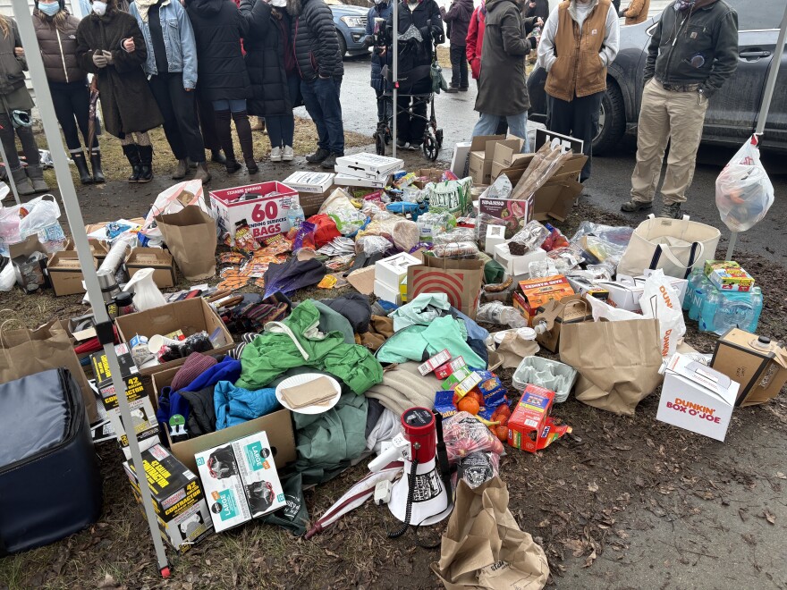 A pile of coffee, trash bags, water, hand warmers, food and other supplies