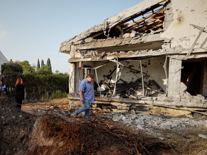 People inspect homes damaged by a projectile launched from Lebanon, in Haniel central Israel, on Thursday.