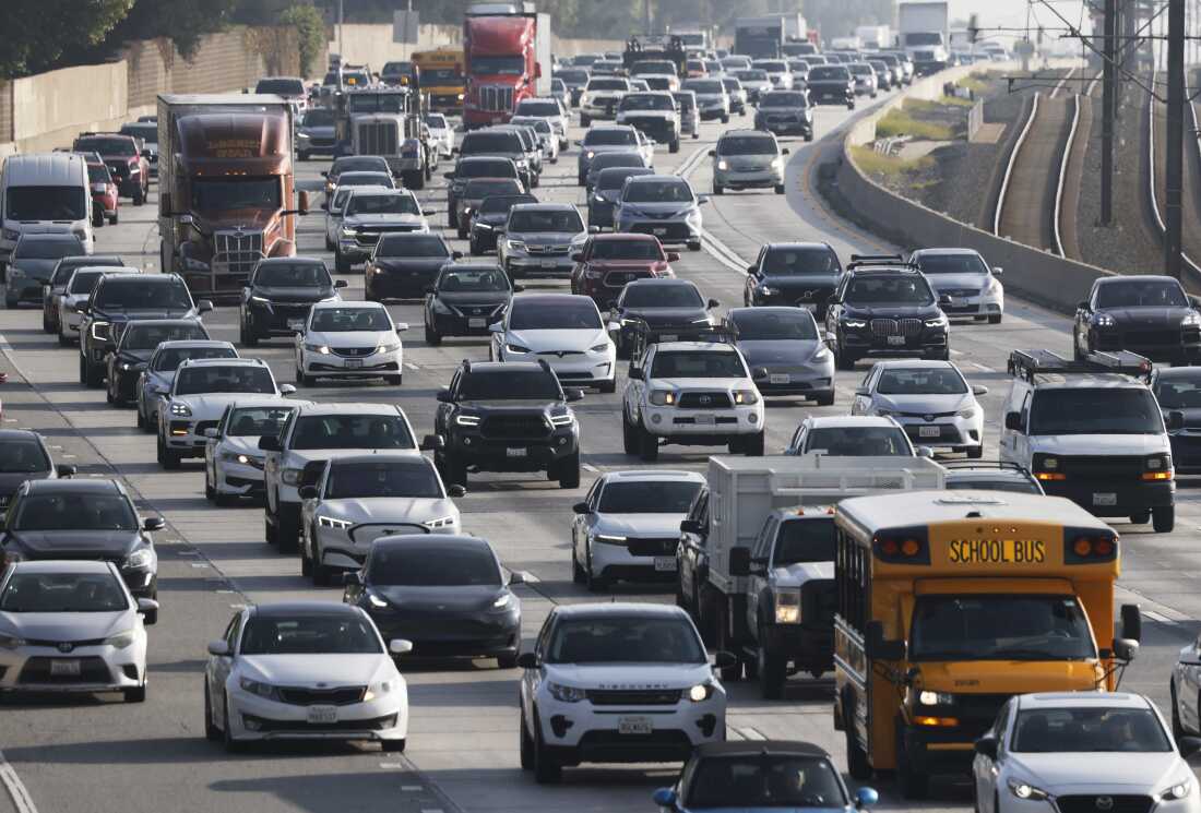 Traffic clogs a highway full of passenger vehicles and tractor-trailers.