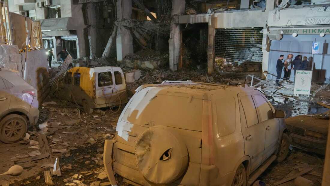 People inspect the site of a destroyed branch of Al-Qard Al-Hassan, a non-bank financial institution run by Hezbollah, which was hit by an Israeli airstrike in central Beirut, Thursday, March 12, 2026.