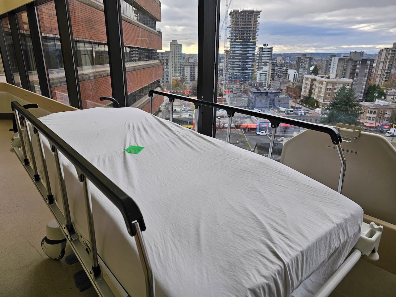 An empty hospital bed in a hallway