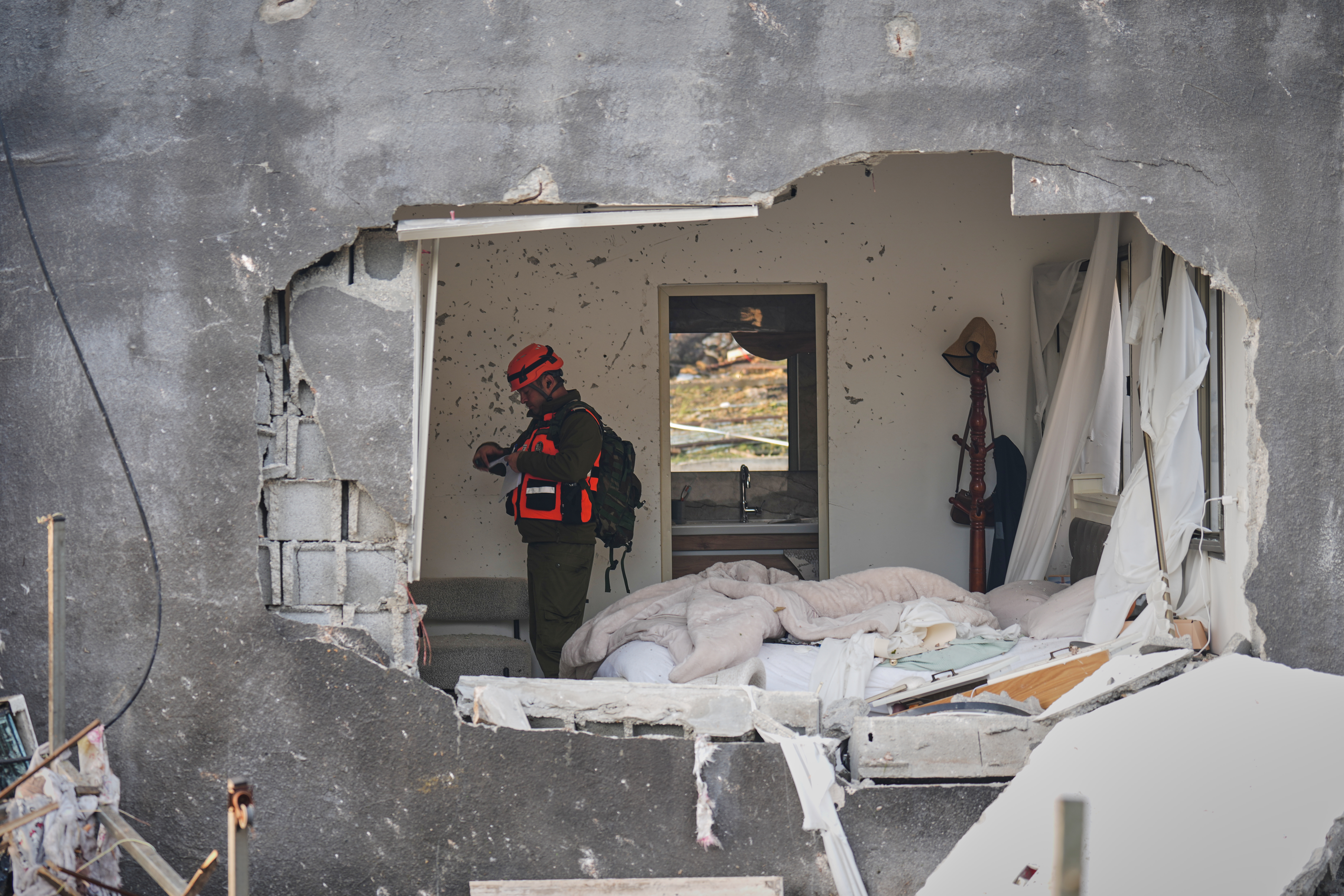 Officers from Israel's Home Front Command inspect a house destroyed by an Iranian missile strike.