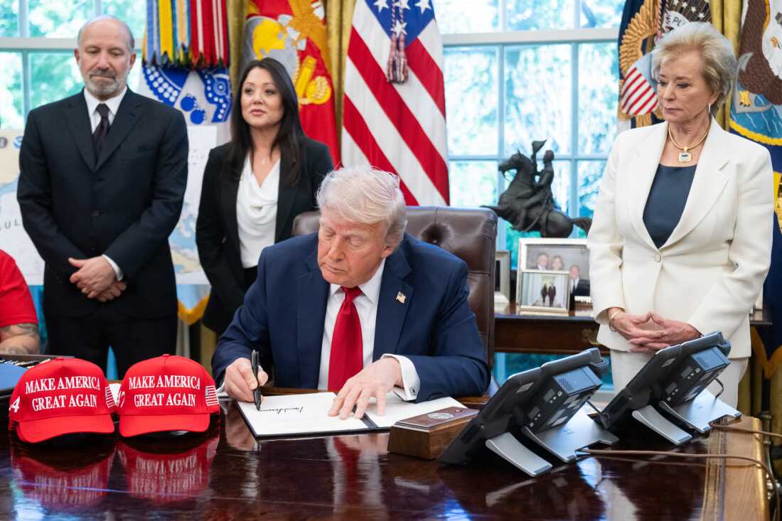 President Trump signs executive orders related to higher education institutions, including apprenticeships, alongside Secretary of Commerce Howard Lutnick and Secretary of Education Linda McMahon in the Oval Office of the White House on April 23, 2025.