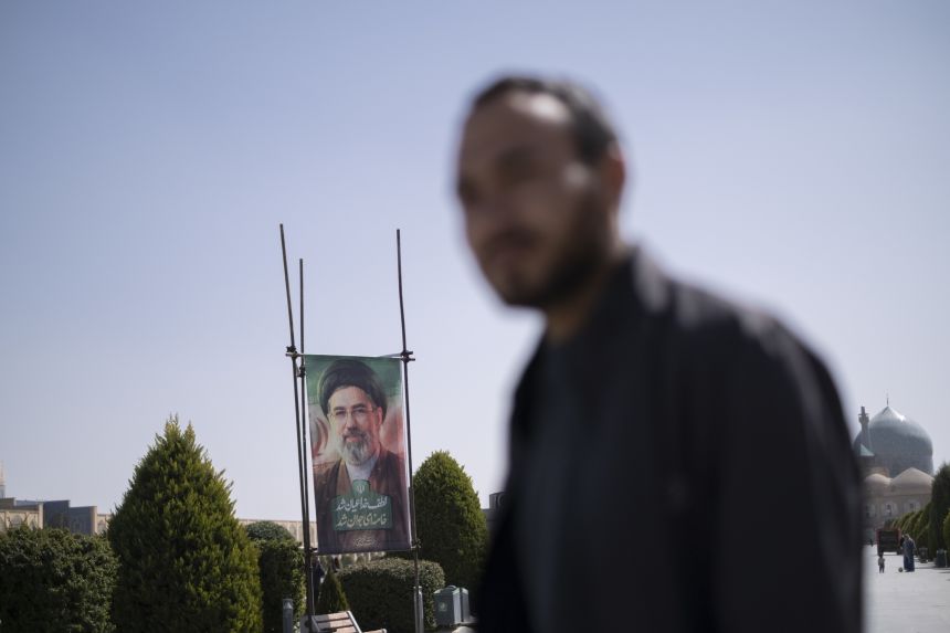 An Iranian man walks past a portrait of Iran's new Supreme Leader, Ayatollah Mojtaba Khamenei, the son of the late Supreme Leader Ayatollah Ali Khamenei, in the historic Naqsh-e Jahan Square in Isfahan, Iran, on March 11, 2026.