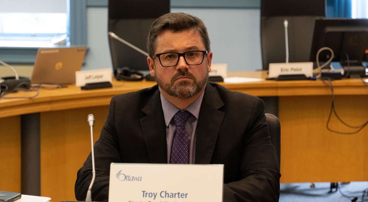 A man sits behind a name tag.