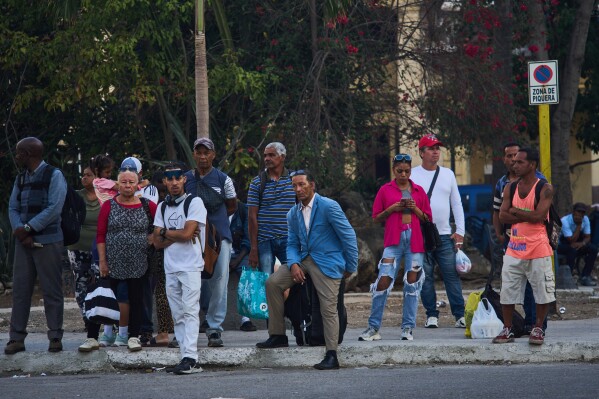 People wait for public transportation in Havana, Cuba, Friday, March 13, 2026. (AP Photo/Ramon Espinosa)