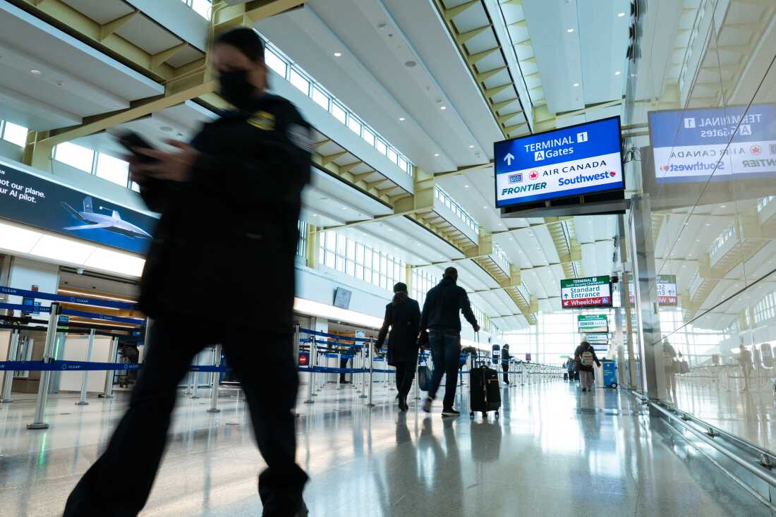 Travelers and staff walk through Ronald Reagan Washington National Airport in Arlington, Va., on Friday. U.S. Transportation Security Administration security officers missed their first full paycheck Friday as a partial funding shutdown of the government approached the one-month mark.