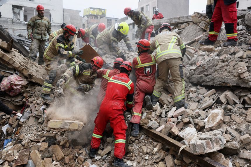 Rescue workers search for survivors in the rubble after a strike in southern Tehran, Iran, on Friday.