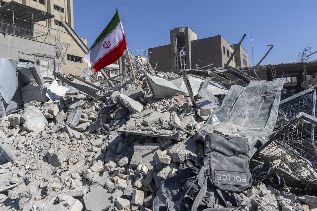 An Iranian flag is planted in the rubble of a police station, damaged in airstrikes yesterday, on March 3, 2026 in Tehran, Iran.