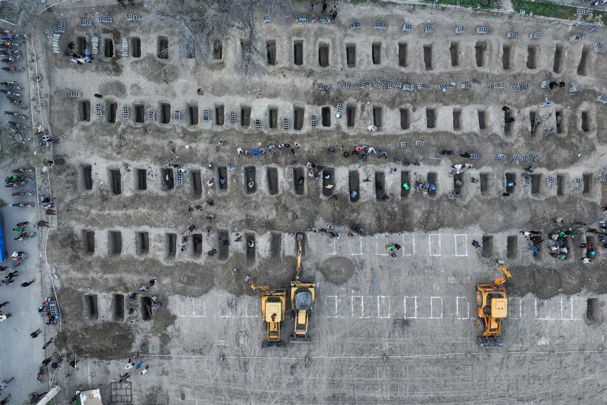 In this aerial photo released by the Iranian Press Center, mourners dig graves during a <a href=