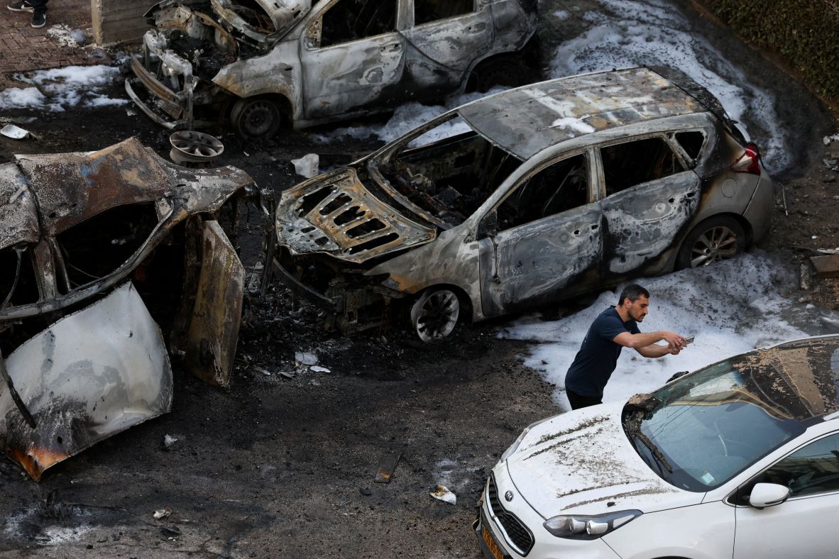 A man surveys damaged cars Tuesday in Bnei Brak, Israel.
