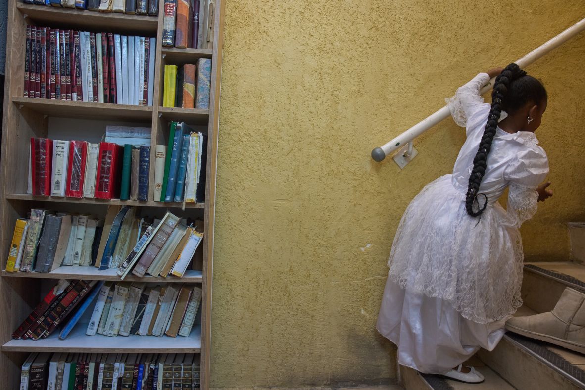 A girl wears a decorative dress for the Jewish festival of Purim inside a bomb shelter synagogue in Hadera, Israel, on Monday.