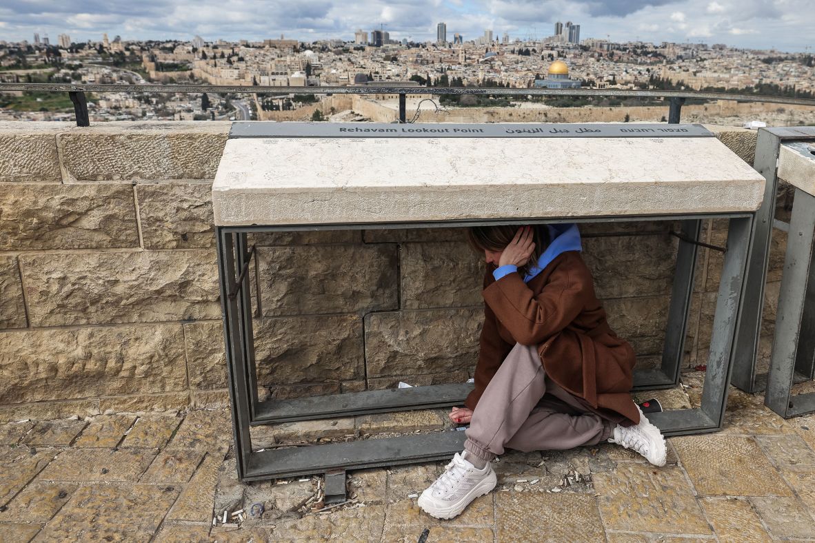 A person takes shelter as sirens sound in Jerusalem on February 28.