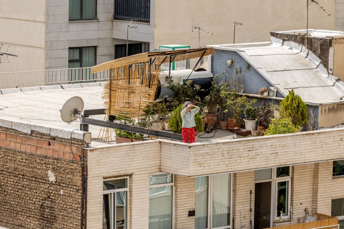 A woman looks out from her rooftop garden in Tehran after large explosions shook the city on February 28.