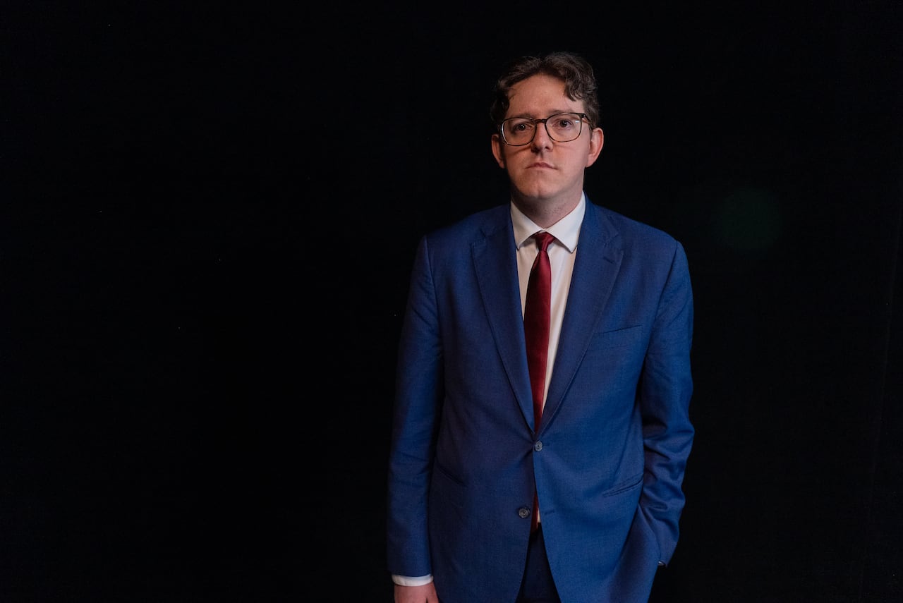 Portrait of a man with glasses in a blue suit