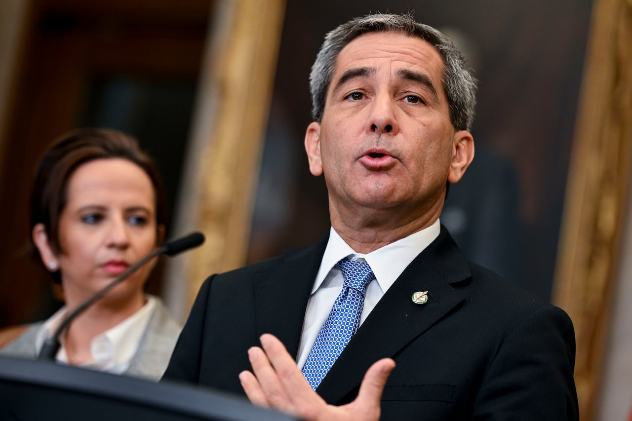A man in a suit standing at a podium.