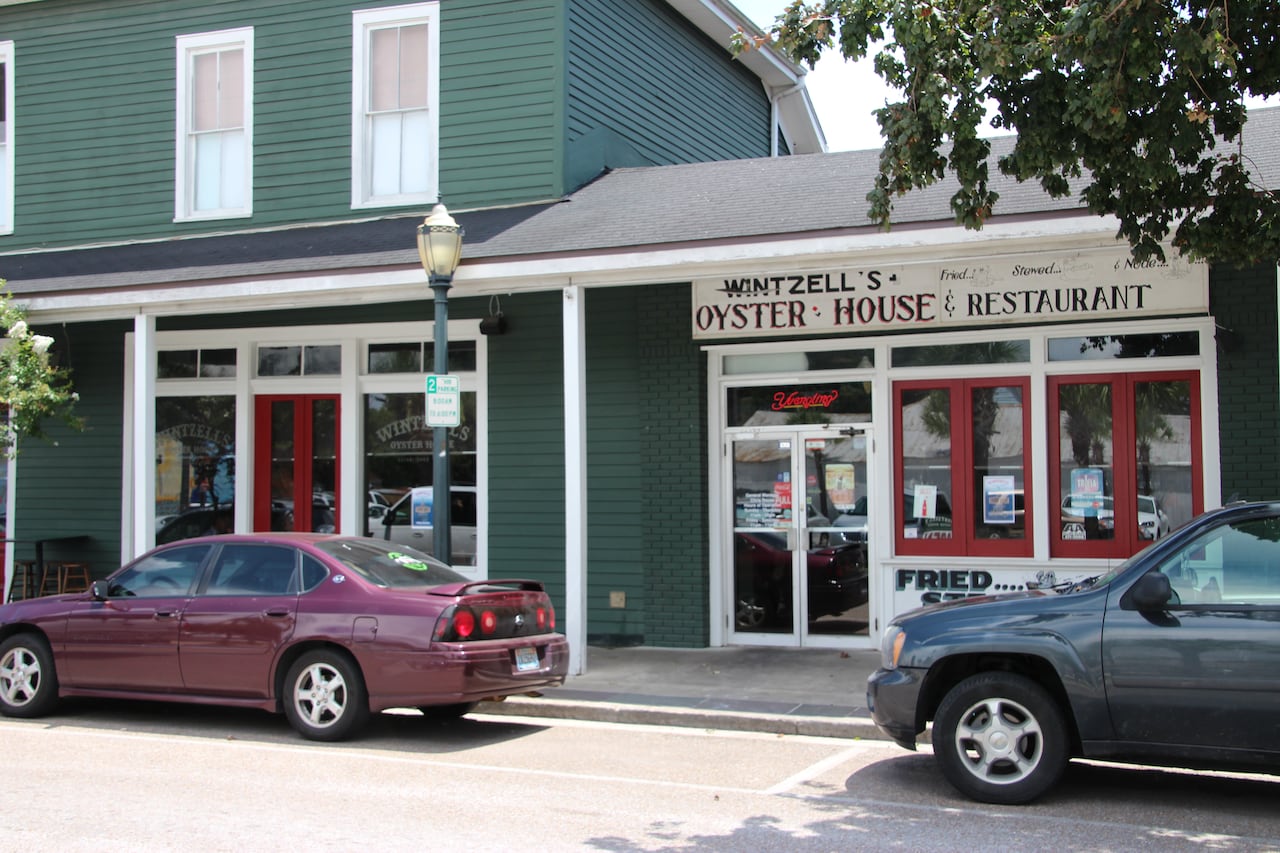 A picture of an oyster house with parked cars out front.